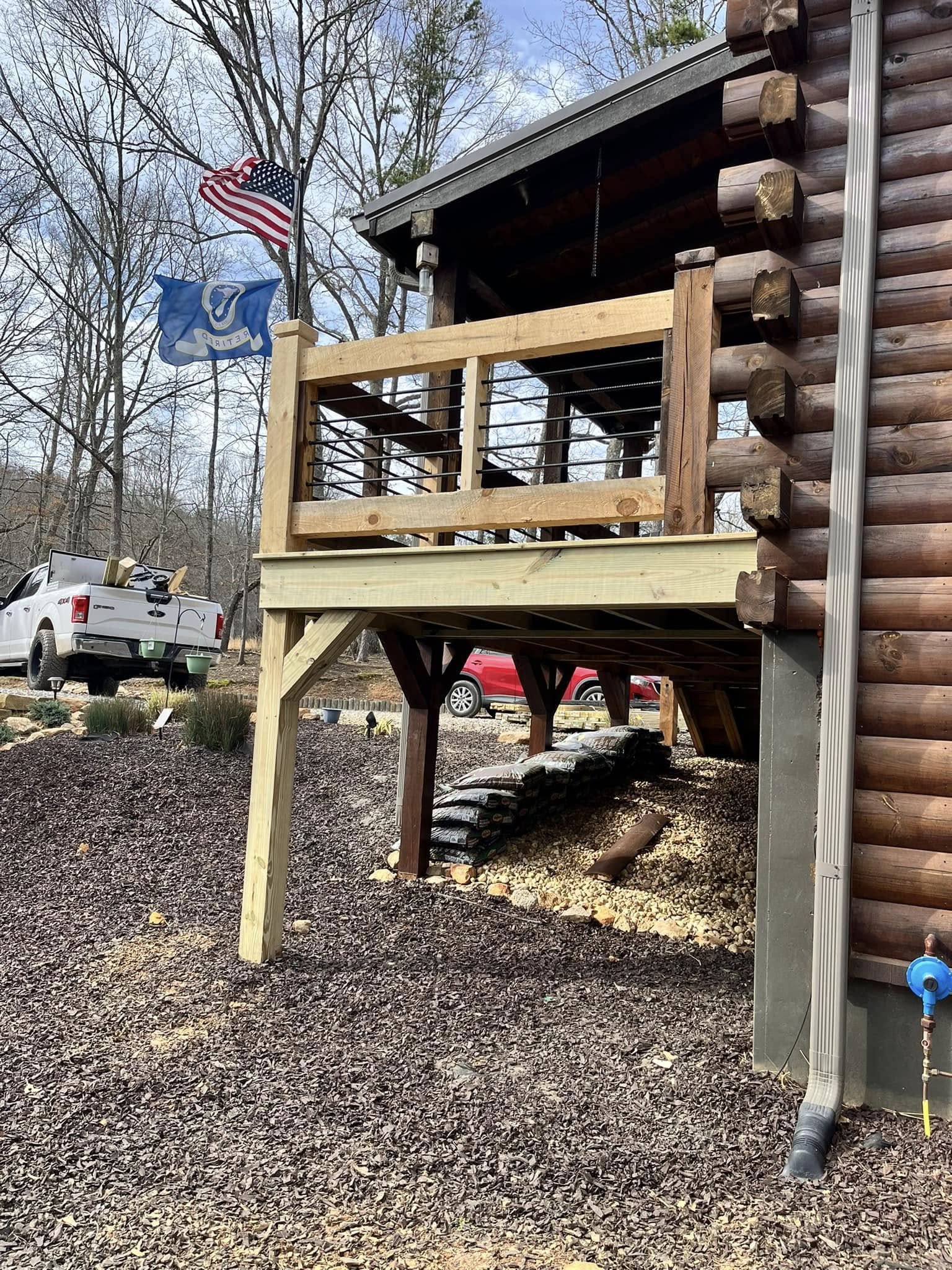 Custom wooden deck with metal railing on a log cabin in Blairsville, GA Custom wooden deck with metal railing on a log cabin in Blairsville, GA